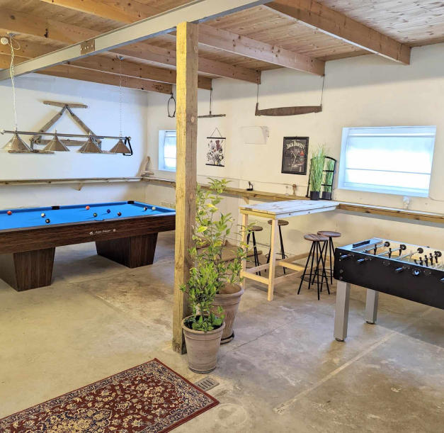 A room with a pooltable and foosball table
