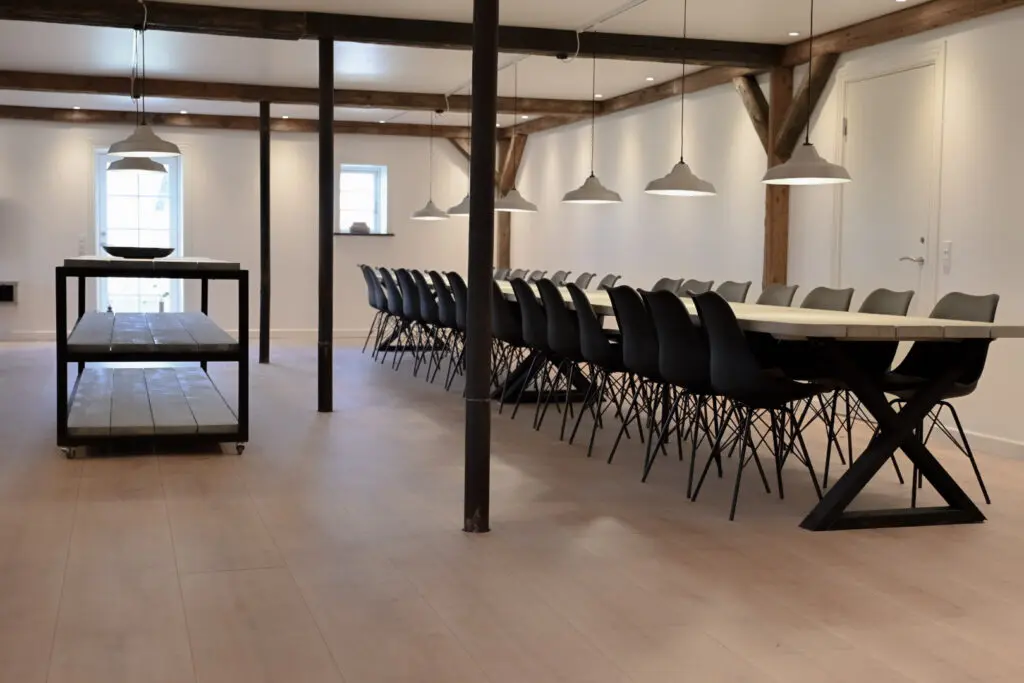 Langt træ spisebord med sorte stole i spisesalen på Horsemosegaard